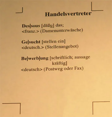 Beigefarbenes Blatt mit Schnittmarken, Überschrift «Handelsvertreter», darunter drei Wörterbucheinträge zu Dessous, Gesucht und Bewerbung mit Lautschrift und Erklärungen.