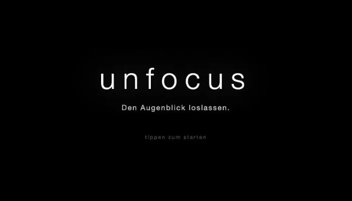 Startbildschirm von Unfocus: auf Schwarz der Schriftzug «unfocus», darunter «Den Augenblick loslassen.» und «tippen zum starten».